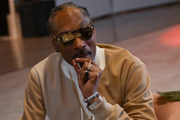 Why does snoop dogg wear a t on his necklace (Unveiling the mystery of his jewelry)
